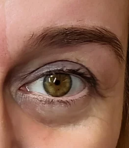 Nahaufnahme eines Auges mit definierter Augenbraue nach dem Färben und Formen.