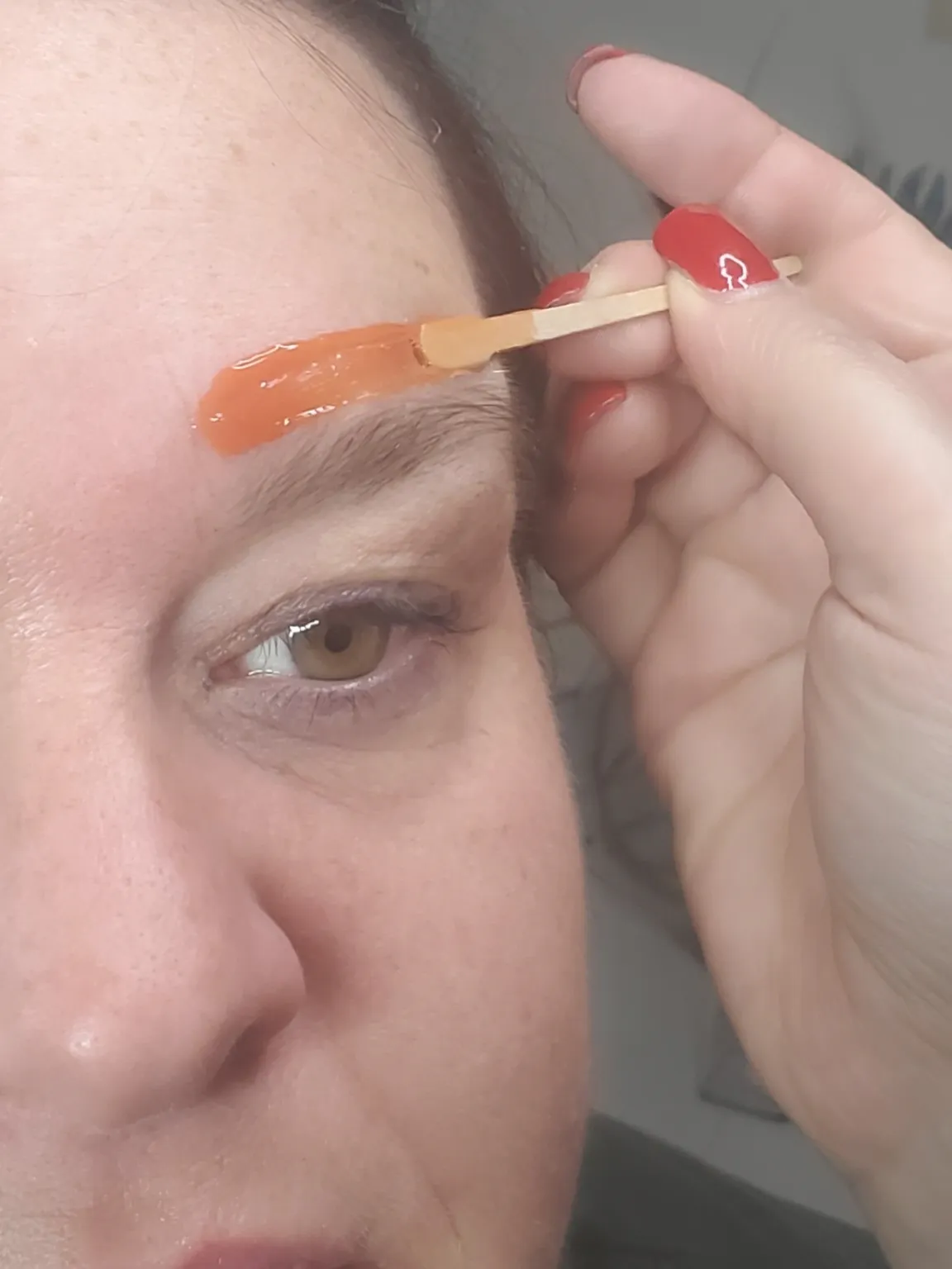 Wachs wird oberhalb der Augenbraue aufgetragen, Vorbereitung zum Formen.