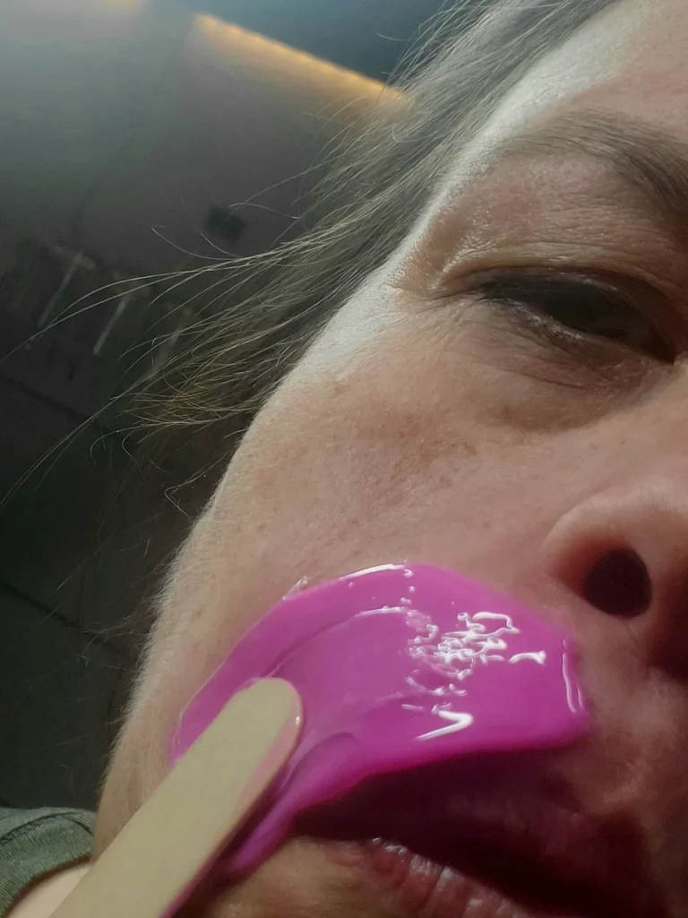 Heisswachs wird mit einem Spatel auf die Oberlippe aufgetragen.