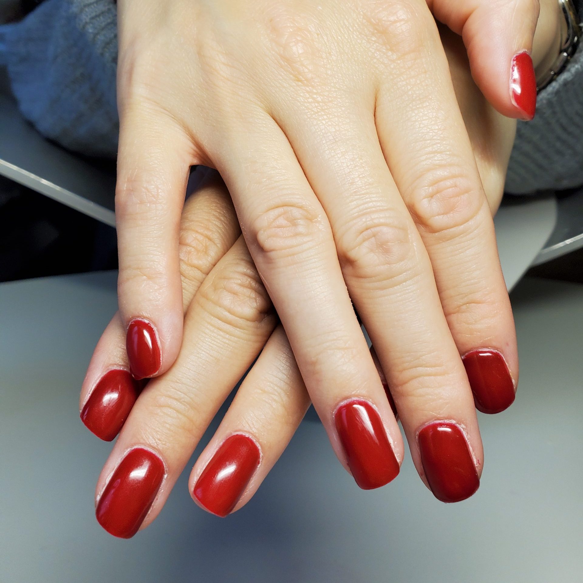 Rote, gl&auml;nzende Fingern&auml;gel auf H&auml;nden